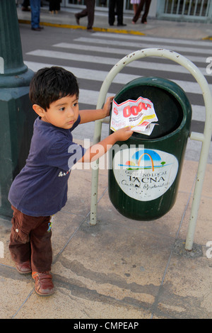 Tacna Peru,Avenida San Martin,Plaza de Armas,Hispanic boy boys,male kid kids child children youngster,preschooler,trash can,city sanitation,paper,flye Stock Photo