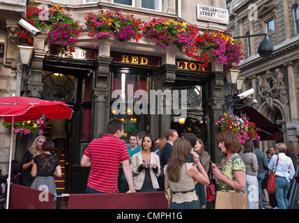 DRINKING PAVEMENT STREET OUTDOORS BUSY PUB people with drinks outside the Red Lion public house Parliament Street London SW1 Stock Photo