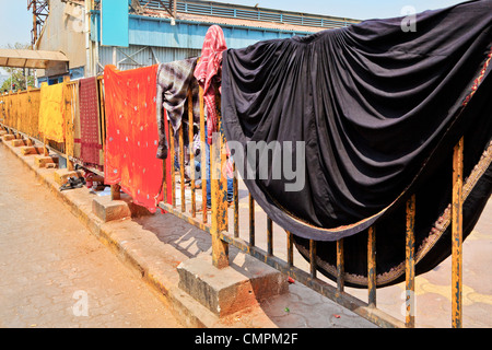 Mahalaxmi Station, Mumbai, India, colors of family washing out to dry on railway railings Stock Photo