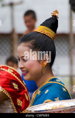 A young Asian woman is wearing traditional clothing prior to the annual Lao New Year Festival in Luang Prabang, Laos. Stock Photo