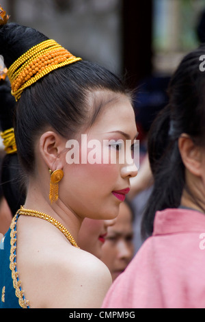 A young Asian woman is wearing traditional clothing prior to the annual Lao New Year Festival in Luang Prabang, Laos. Stock Photo