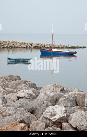 A Lancashire Nobby traditional inshore fishing boat, and a dinghy, moored at high tide on a calm day  at Morecambe, Lancashire Stock Photo