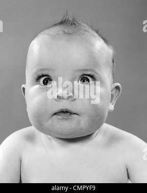 1950s CLOSE-UP OF BABY WITH BULGING EYES STARING CROSS-EYED PORTRAIT STUDIO Stock Photo