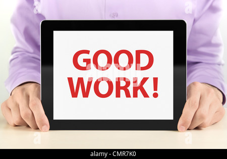 Manager holding tablet pc with 'Good Work' text on screen. Stock Photo