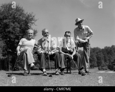 1940s 1950s FOURSOME OF MEN PLAYING GOLF SITTING WAITING TO TEE-OFF Stock Photo