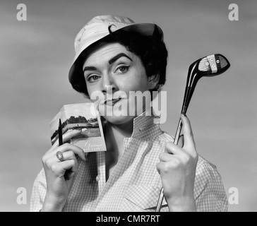 1950s 1960s PORTRAIT WOMAN IN HAT HOLDING GOLF CLUB & SCORECARD WITH PERTURBED LOOK ON FACE LOOKING AT CAMERA Stock Photo