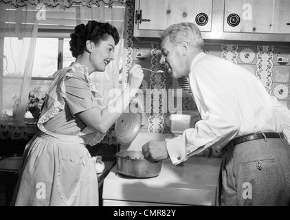 https://l450v.alamy.com/450v/cmr82y/1950s-housewife-in-kitchen-having-husband-taste-food-on-stove-cmr82y.jpg