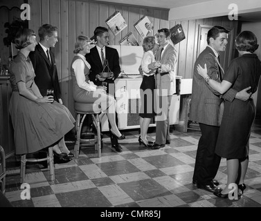 1950s 1960s TEEN COUPLES HAVING PARTY DANCING IN REC ROOM Stock Photo