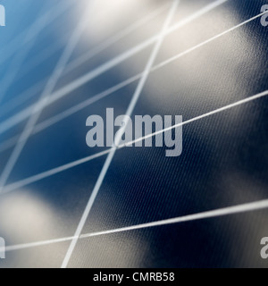 Solar energy. Photo voltaic panels. Clouds mirroring in the solar panel. Shallow DOF. Squared composition. Stock Photo