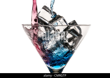 Blue and red liqueur poured into a glass with ice cubes on white background Stock Photo