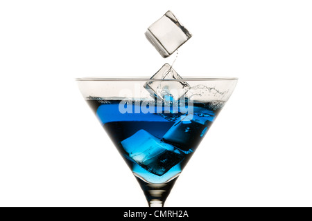 Dropping ice cubes into martini glasses on white background Stock Photo