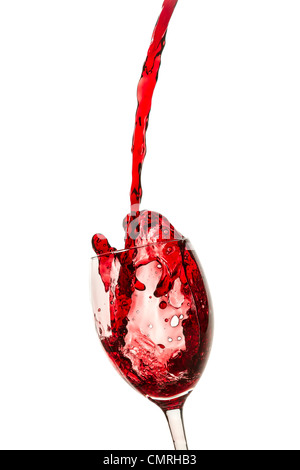 Spilling red wine in the glass on white background Stock Photo