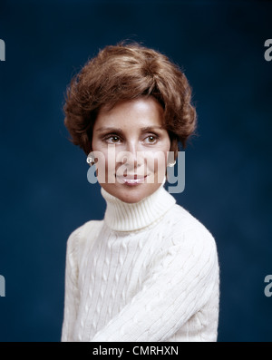 1970s PORTRAIT OF SMILING WOMAN WEARING CABLE KNIT TURTLENECK SWEATER AND SILVER EARRINGS Stock Photo