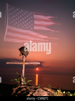 1970s MONTAGE TATTERED AMERICAN FLAG SUNSET SOLDIERS MILITARY HELMET ON CROSS GRAVE MARKER Stock Photo