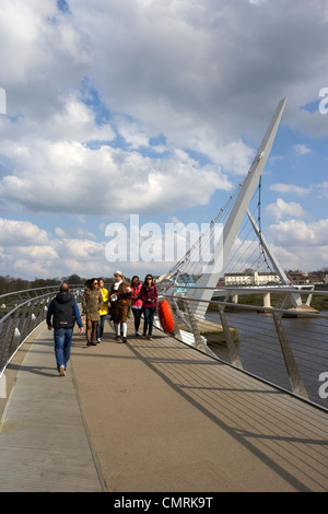 tourists crossing the new peace bridge in Derry city county londonderry northern ireland uk. Stock Photo