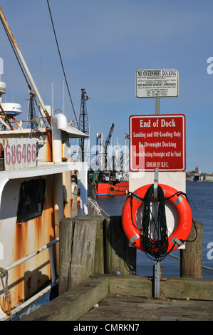 Warning signs at the end of wharf overlooking the fishing fleet in New Bedford Harbor, Massachusetts Stock Photo