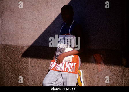 1980 1980s RETRO AFRICAN AMERICAN BOY TEEN SELLING NEW YORK POST NEWSPAPERS Stock Photo