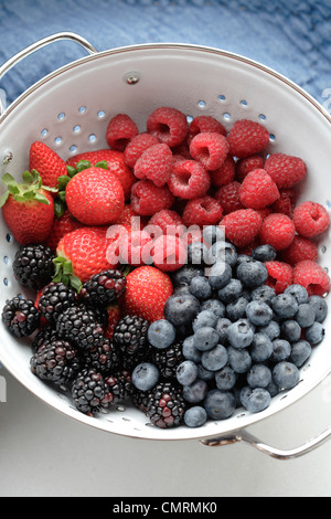 Various fresh berries in colander Stock Photo