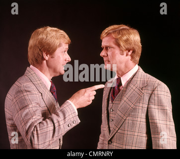 1970 1970s RED HAIRED MAN IN SUIT POINTING AT DUPLICATE CLONE FACIAL EXPRESSIONS RETRO Stock Photo