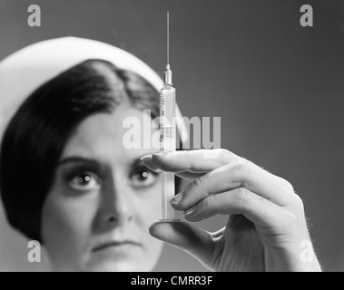 1960s NURSE ADJUSTING DOSAGE INJECTION HYPODERMIC NEEDLE Stock Photo