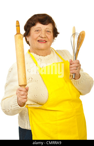 Happy elderly woman holding kitchen utensils isolated on white background Stock Photo