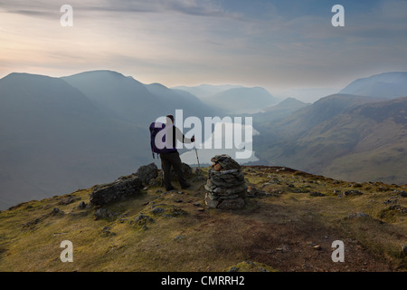 Hill Walker and the Buttermere Valley in Misty Late Evening Light From the Summit of Fleetwith Pike Lake District Cumbria UK Stock Photo