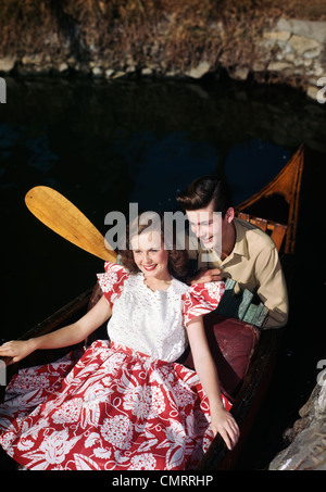 1940s 1950s SMILING TEEN COUPLE RIDING IN CANOE Stock Photo