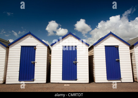 UK, England, Devon, Torquay, Goodrington Sands, blue and white painted beach huts below blue summer sky Stock Photo