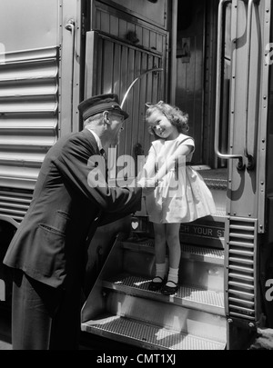 1950s CONDUCTOR GREETING LITTLE GIRL ON TRAIN STEPS Stock Photo