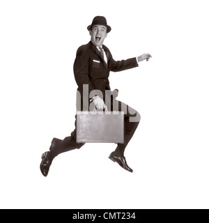 1960s SALESMAN LEAPING IN AIR HOLDING BRIEFCASE AND WEARING HAT LOOKING AT CAMERA Stock Photo