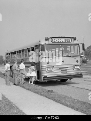 1960s ELEMENTARY SCHOOL CHILDREN GETTING ON SCHOOL BUS Stock Photo
