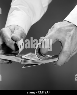 1960s CLOSE-UP OF MAN'S HANDS SHUFFLING DECK OF CARDS Stock Photo