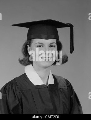 1960s PORTRAIT SMILING YOUNG WOMAN WEARING GRADUATION CAP AND GOWN LOOKING AT CAMERA Stock Photo