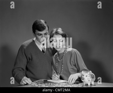 1960s COUPLE COUNTING COINS FROM PIGGY BANK Stock Photo