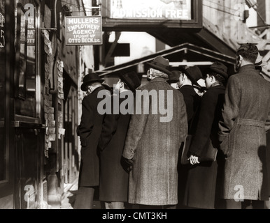 1930s GREAT DEPRESSION COLD MEN STANDING IN EMPLOYMENT LINE LOOKING FOR WORK Stock Photo