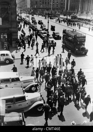 1930s PEDESTRIAN CROWD CROSSING INTERSECTION 42nd STREET & 5th AVENUE NYC CARS TAXIS DOUBLE DECKER BUSES STREET AERIAL VIEW Stock Photo