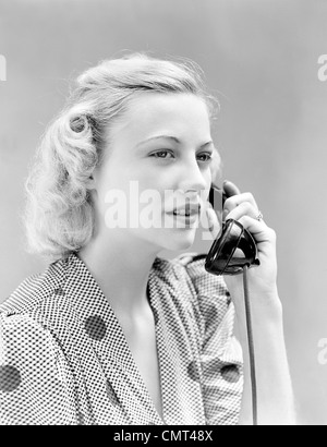 1930s 1940s BLOND WOMAN TALKING ON TELEPHONE WEARING POLKA-DOT DRESS SMILING Stock Photo