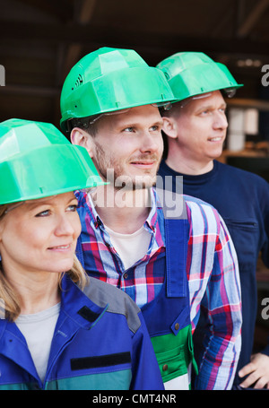 Three colleagues in green helmets Stock Photo