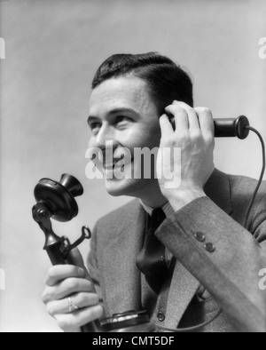 1920s 1930s MAN TALKING ON CANDLESTICK PHONE Stock Photo
