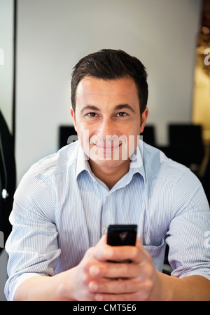 Portrait of happy business man holding mobile phone Stock Photo