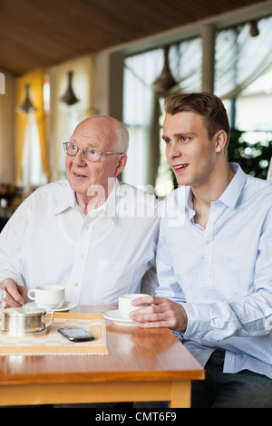 Old man and young man drinking coffee Stock Photo