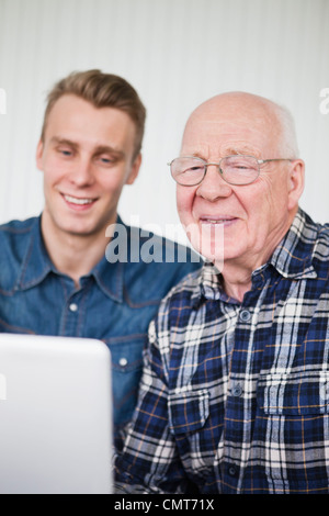 Elderly man and guy using laptop Stock Photo