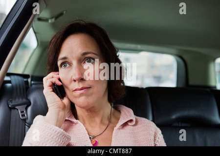 Close-up of serious woman talking on phone Stock Photo