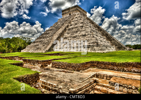 Chichen Itza, El Castillo (Kukulcan), Maya historical site, Yucatan state, Mexico, The Pyramid was built for astronomical purposes. The construction of the Kukulcán Pyramid at Chichén Itzá was planned so that each Vernal Equinox the dying sun would cast a shadow of a serpent writhing down the steps of the pyramid. Every year over 40,000 people make the trip to the great pyramid to watch in awe as the snakes diamond backed body slowly appears.If you stand facing the foot of the temple and shout the echo comes back as a piercing shriek. Also, a person standing on the top step can speak in a norm Stock Photo