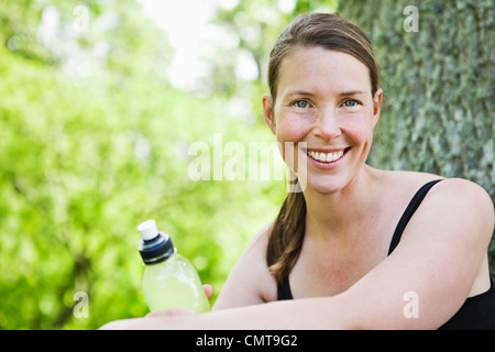 Portrait of smiling woman holding sport drink bottle Stock Photo