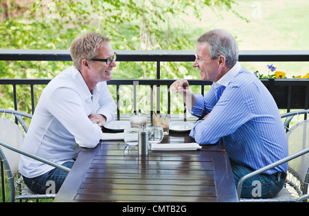 Friends at restaurant talking Stock Photo