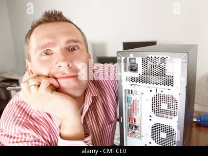 Repairman with computer or private owner of the stuff thinking how to repair it. Stock Photo
