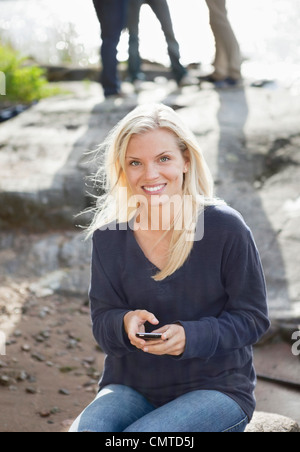 Smiling woman using mobile phone Stock Photo