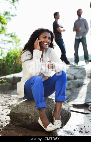 Smiling woman sitting on rock Stock Photo