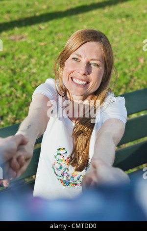 Happy woman holding hands of man at park Stock Photo